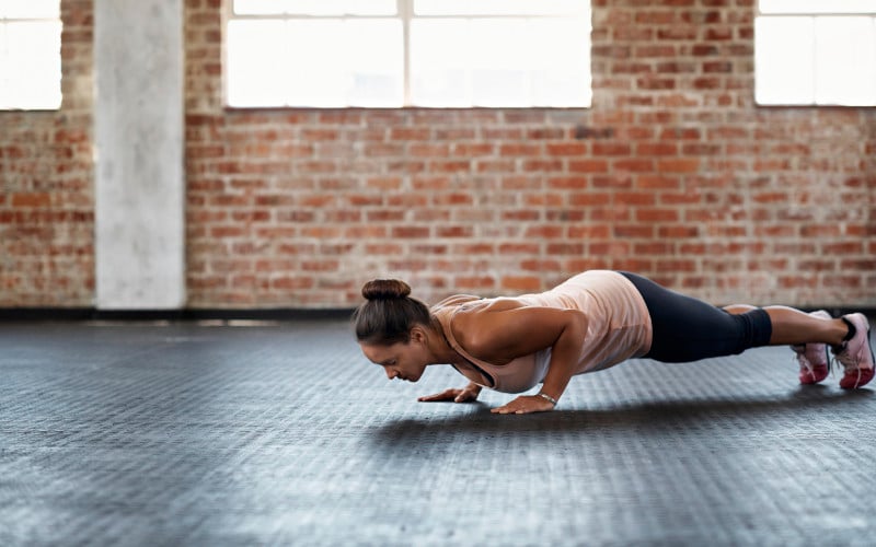 woman does a push-up on the gym floor