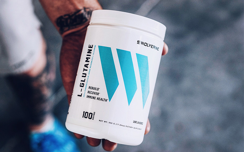 Man holding Swolvering L-Glutamine bottle in hand.