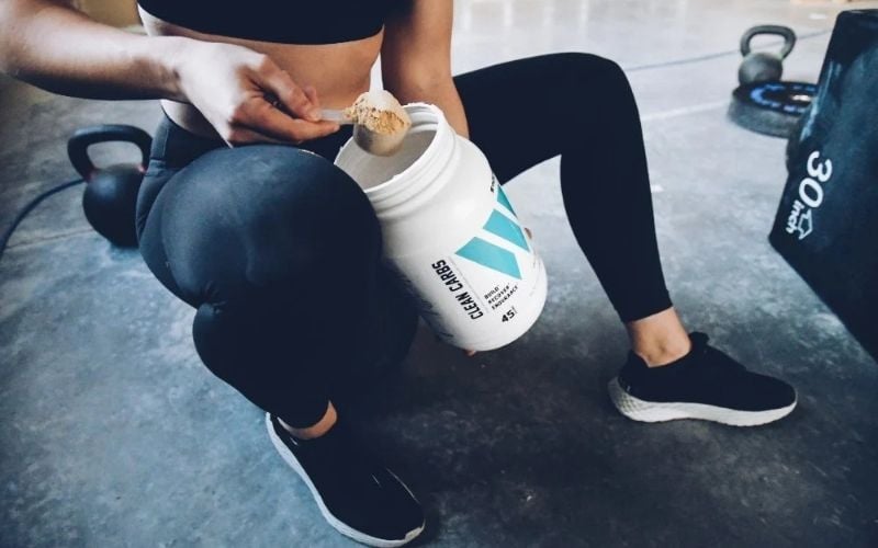 Swolverine athlete scooping Clean Carbs.