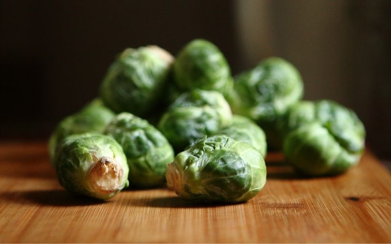 Close up of brussels sprouts on bamboo cutting board.