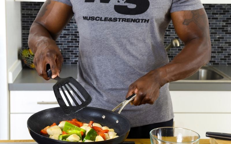 Close up shot of a muscular man making healthy food in the kitchen.