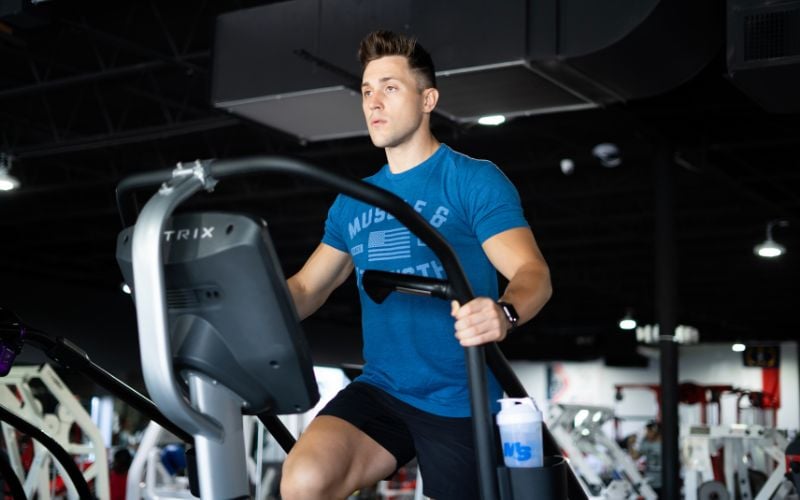 Fit man doing cardio on the stairmaster in the gym.