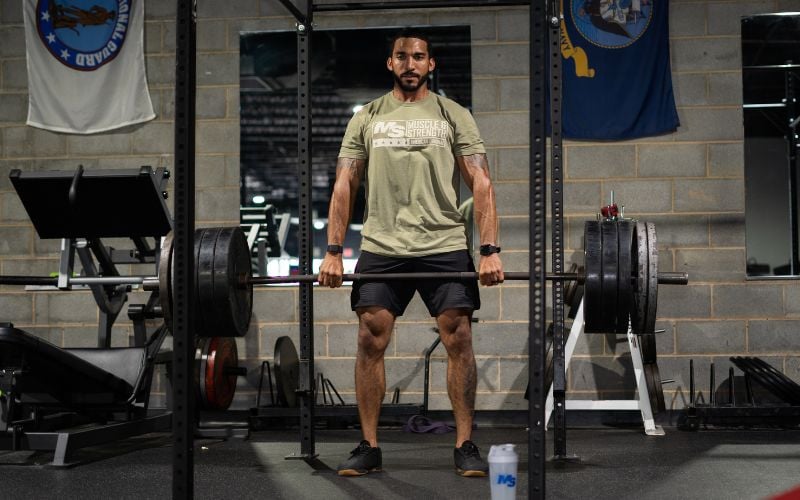 Strong man in the gym doing heavy barbell deadlifts