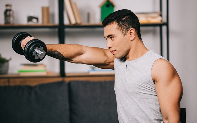 Muscular man working out at home