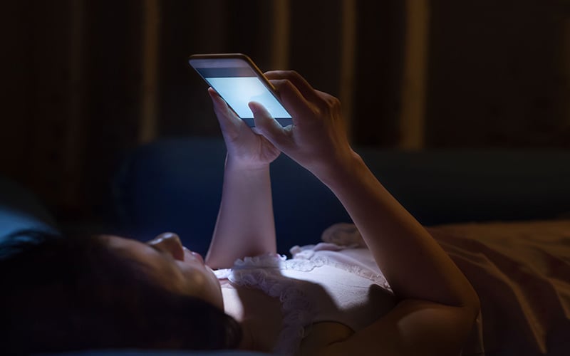 Woman checking her phone during night