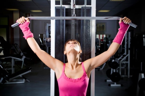 Woman performing lat pull downs.